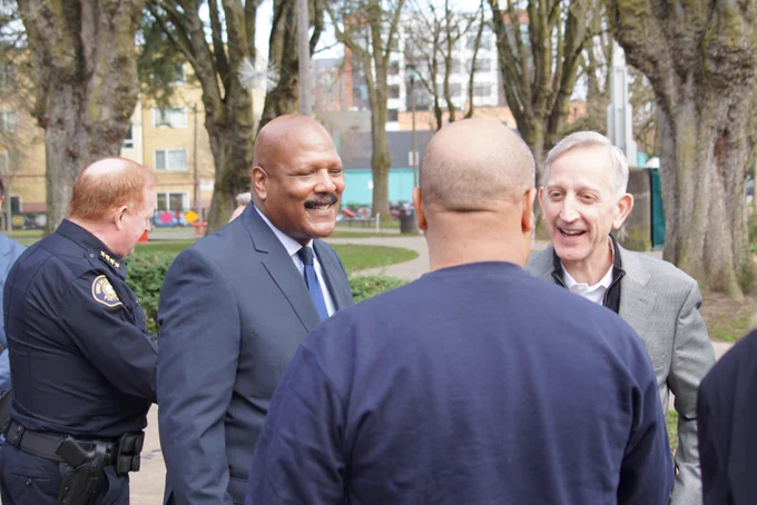 Mayor Wilson speaking to people at a public safety event at Dawson Park with Pastor Hennessee and Chief Bob Day visible in the photo