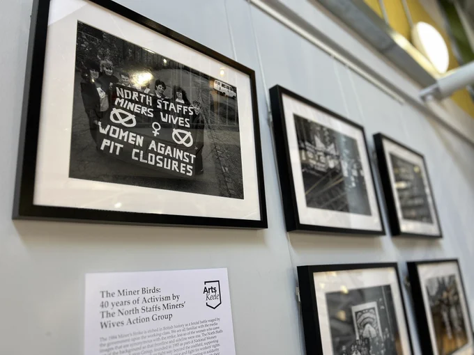 Exhibition wall displays a series of framed black and white photographs, including one titled 'North Staffs Miners' Wives' by The North Staffordshire Miners' Wives Action Group. 