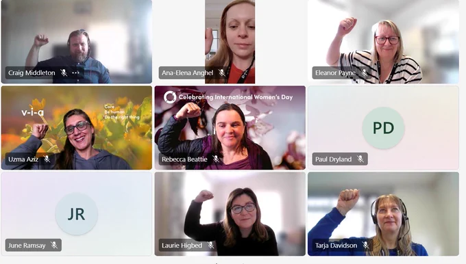 screenshot of people on a teams call holding up their arm in solidarity with women