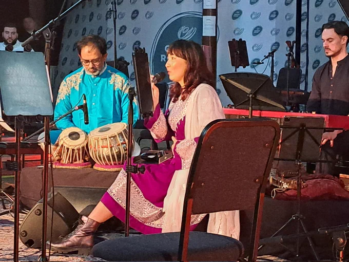 Afghan female singer with Tabla player and pianist on stage performing 