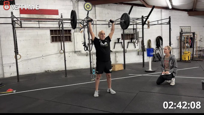 Me completing the thruster with the barbell overhead