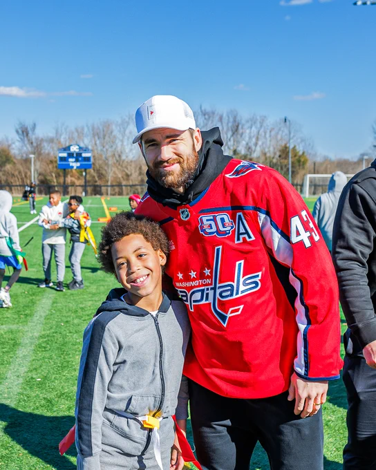 Tom Wilson poses for a photo with an athlete from Flag Star Football Foundation.