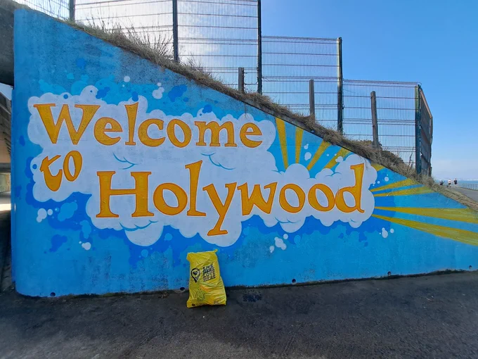 Entrance to the underpass at Holywood with a mural painted on the wall, Welcome to Holywood, along the coastal path