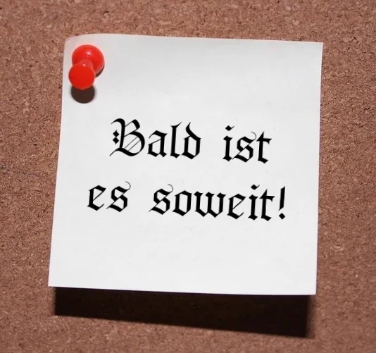 Zettel an einer Pinwand mit der Aufschrift "Bald ist es soweit!"
