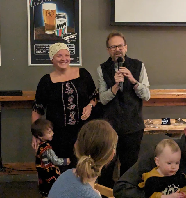 A photo of Shelly, her son, and Christopher Merrill smiling at the 2023 Fall Residency closing celebration.