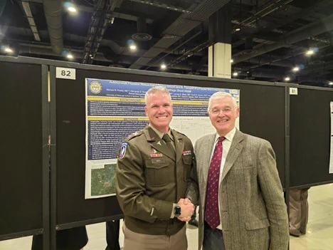 Ron Poropatich, MD attending the AMSUS Meeting at the National Harbor discussing with COL Sean Hipp, MD stationed at West Point, the Pitt poster: "Autonomous Precision Resuscitation During Ground and Air Transport of a Porcine Non-compressible Torso Hemorrhagic Shock Model"