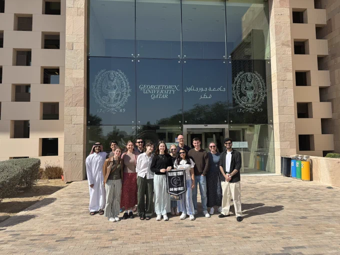 Group of students standing in front of Georgetown University in Qatar building.