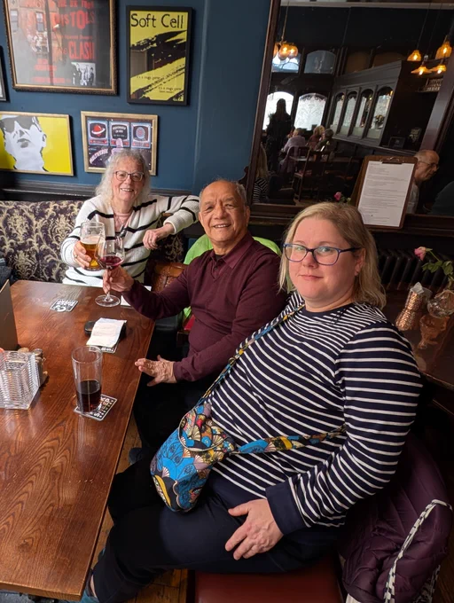 2 women 1 man at table smiling in a pub