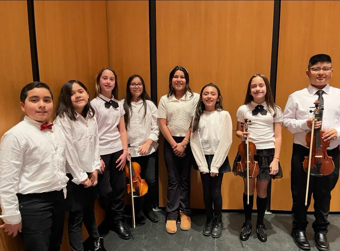Students standing in a row with musical instruments