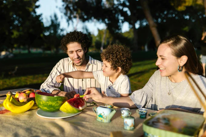 A family eats healthy food outside.
