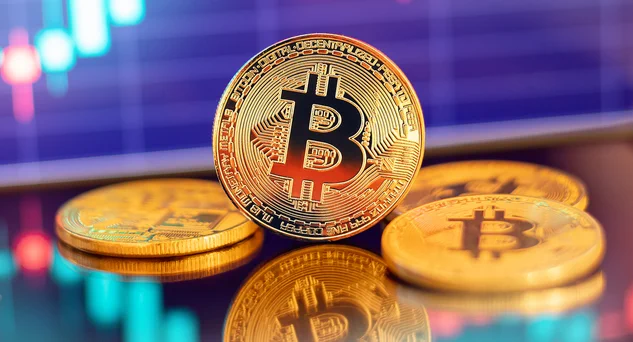 A few gold Bitcoins on a desk.