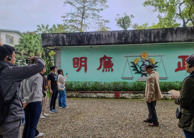 Group of people taking photos in front of a wall with a colorful mural at the National Museum of Human Rights.