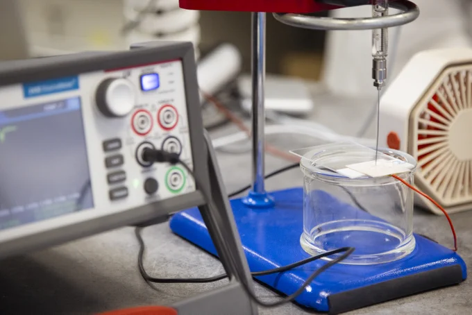 A set up of an experiment in a lab measuring the electrical charge of water droplets. 