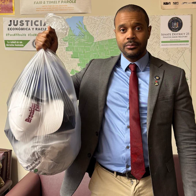 Sen. Jabari Brisport holding a trash bag