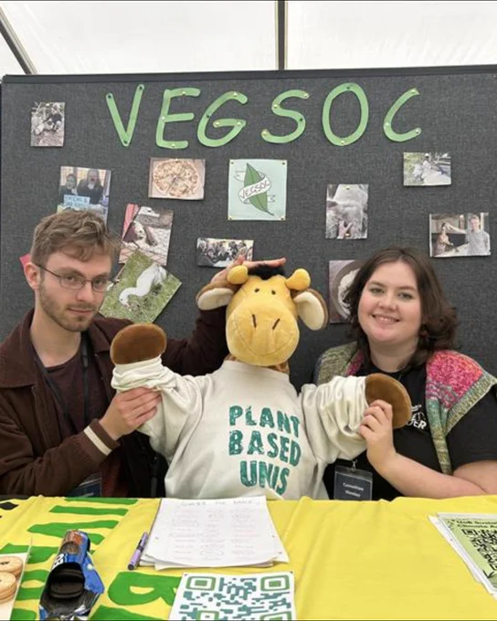 Image of two students smiling at the camera holding a stuffed toy and are a part of the Veg Society.