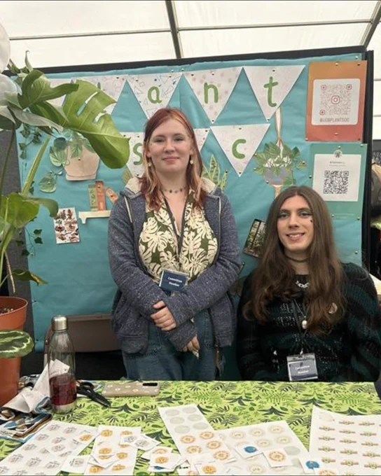 Image of two students smiling at the camera  and are a part of the Plant Society.