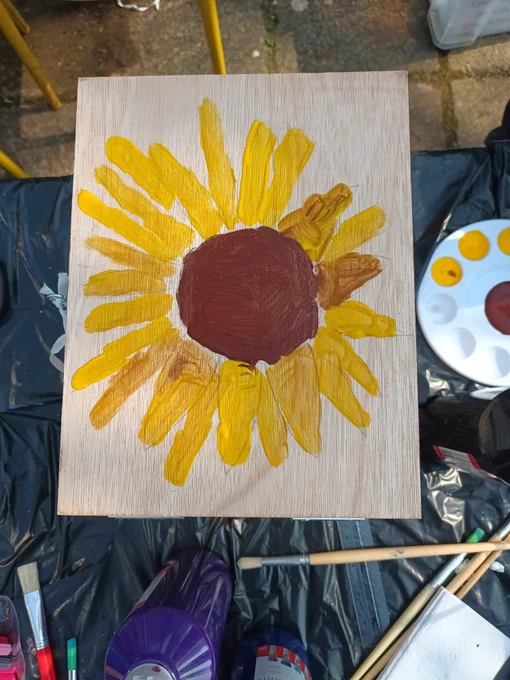 A wooden composting box with a sunflower painted on its lid