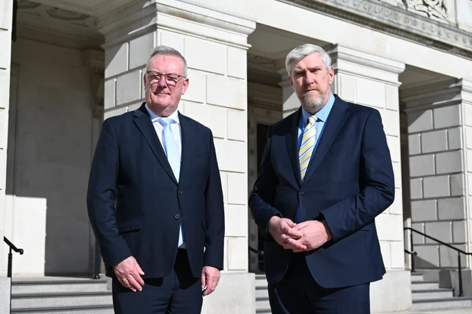 Minister O'Dowd and Nesbitt standing on the steps of Stormont.