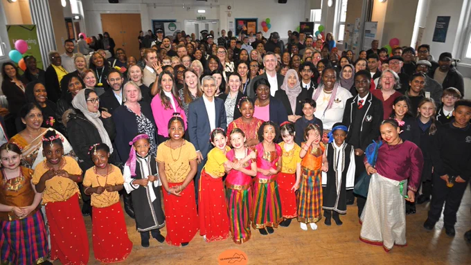 Group shot with the Mayor of London at the centre of a large hall filled with members of the community 