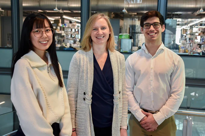 Full-color photo of grad student, professor, and undergraduate chem major standing in Frick Lab. 