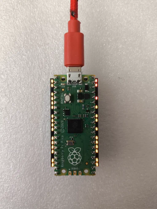 Raspberry Pi Pico plugged on top of the Pico Indicator black PCB which has an amber LED for each of the exposed GPIO pins and a red LED for VBUS/VSYS and 3V3 illuminated.
