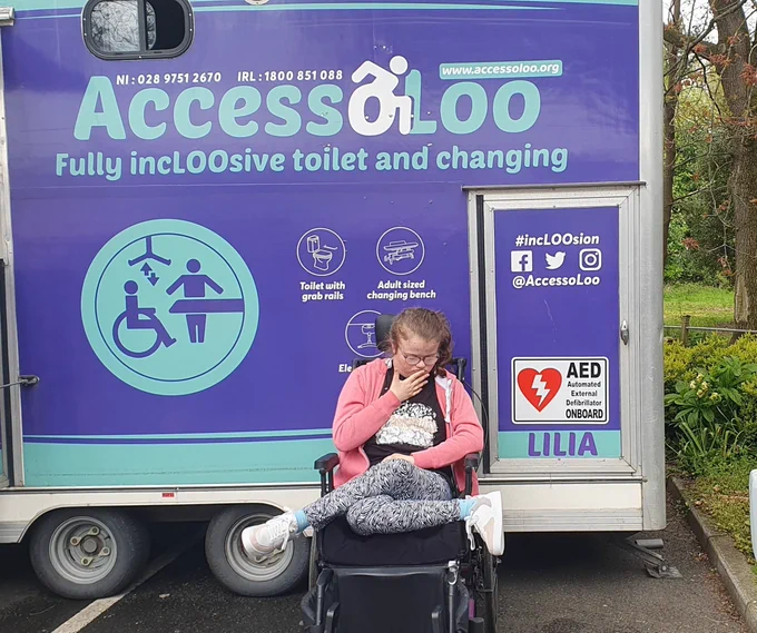 Our wheelchair user daughter Lilia with the mobile changing places toilet named after her. The text on the side of the @Accessoloo van says Fully inclusive toilet & changing 