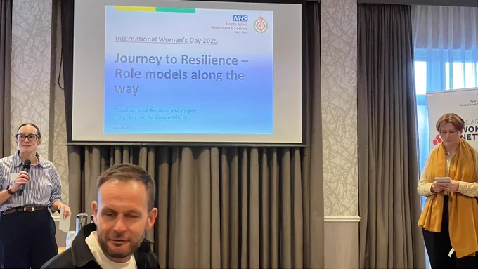 CarolineLloyd, Resilience Manager and Lucy Fletcher, Resilience officer stood in front of projector screen presenting (with Dan Ainsworth at the front bottom of the pic also in view)