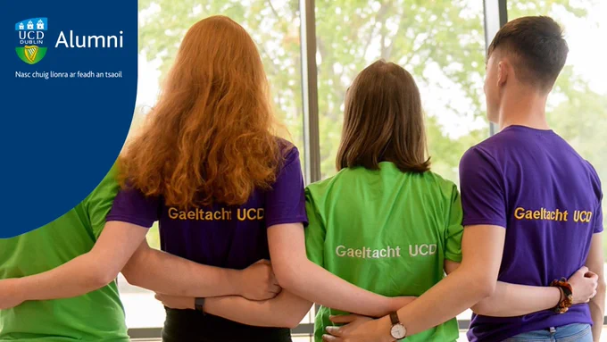 Ceithre duine i dt-léine corcora agus glasa leis an teideal ‘Gaeltacht UCD’ orthu. Tá a ndromanna ar aghaigh linn.