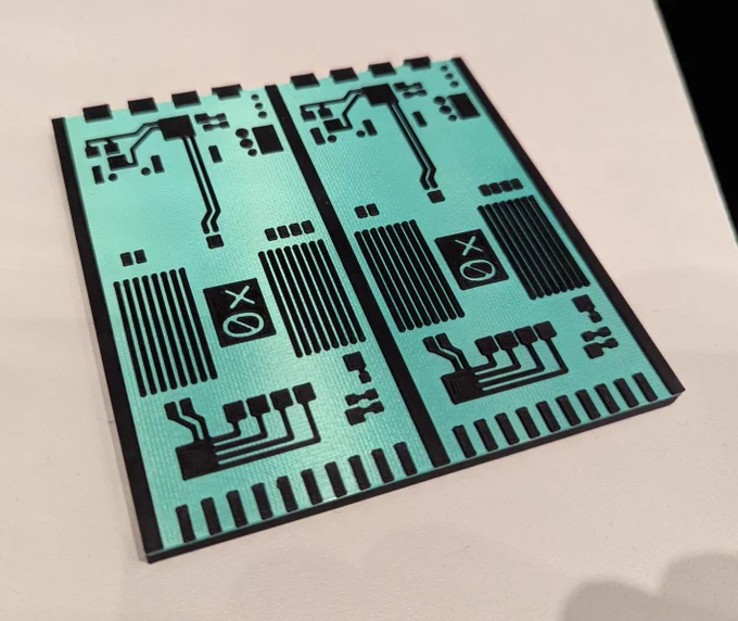 A coaster depicting two teal-colored printed circuit boards placed side by side on a white surface. The coaster features the Oxide logo and detailed black circuitry patterns.