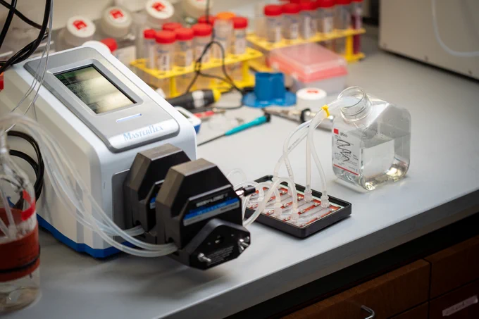 A Mastercycler nexus gradient thermal cycler on a laboratory bench surrounded by various lab equipment and containers.