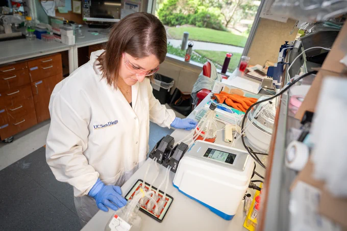A scientist in a white lab coat conducts an experiment in a laboratory, using precision equipment and various scientific tools.