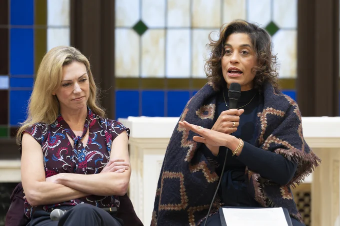 2 women speaking before an audience.