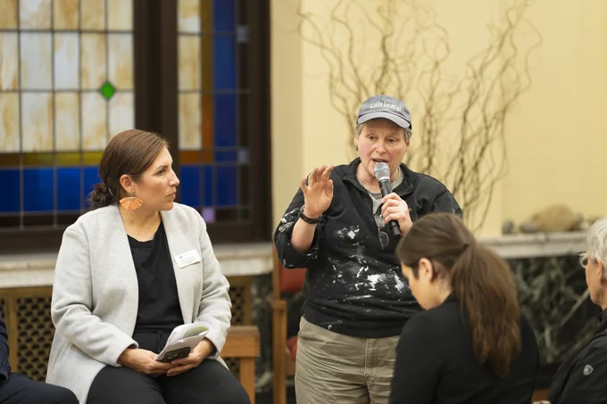 2 women speaking before an audience.