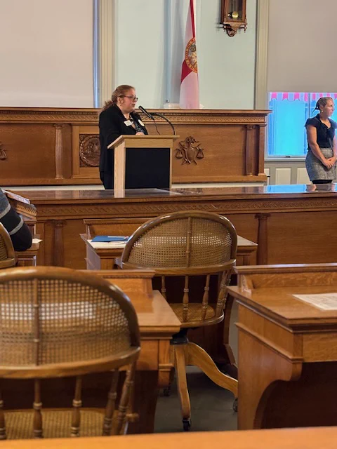 Photo of Jenny speaking at the podium