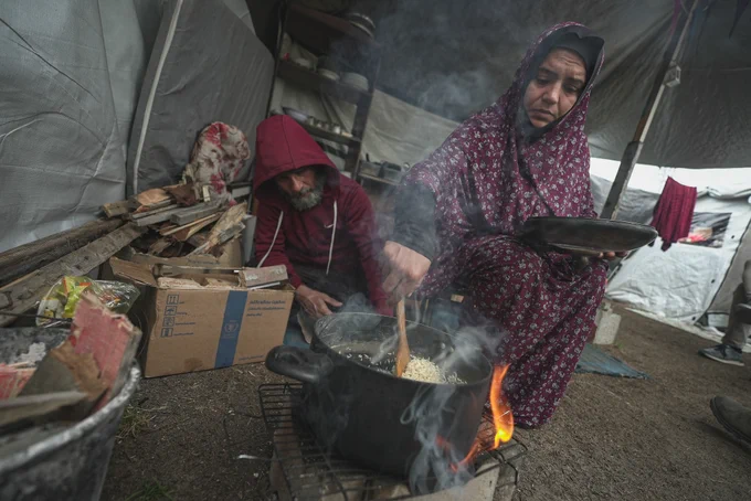 A woman in Gaza cooks rice in February 2025. Since 2 March, people in Gaza have not received food aid. Commercial food prices are surging, and the situation is dire. Photo: WFP/Jaber Badwan
