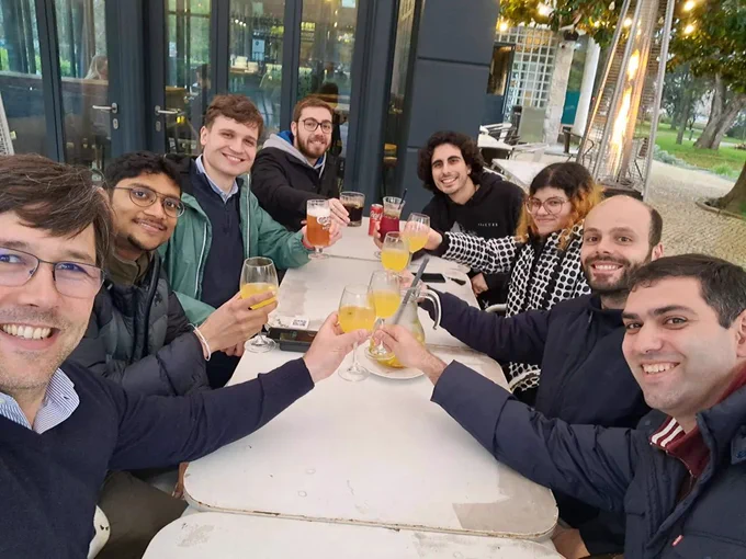 welcome and goodby drinks on a sunny afternoon. Table with 8 researchers toasting