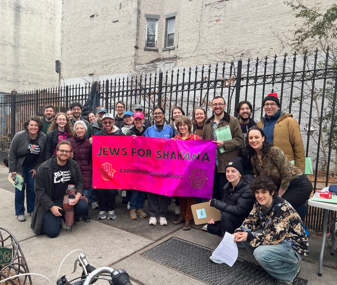 Photo of over 25 people gathered around a pink banner that says: Jews For Shahana: caring for our neighbors.