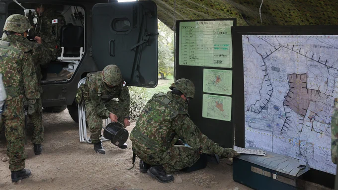 U.S. Soldiers and Japan Ground Self-Defense Force soldiers construct a joint tactical operations center and put up maps and charts. (Photo Credit:Sgt. Austan Owen 
5th Mobile Public Affairs Detachment; modified by the Army Geospatial Center)