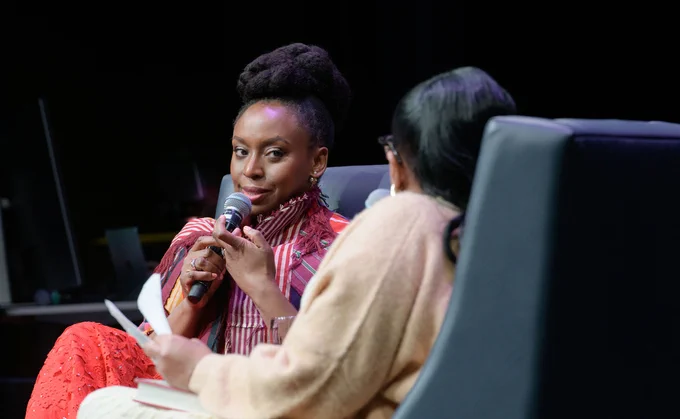 A close-up shot of Chimamanda Ngozi Adichie speaking to the event’s host, capturing her expressive gestures and poised presence.