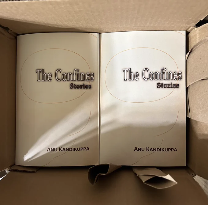 A box holding multiple copies of the book THE CONFINES by Anu Kandikuppa