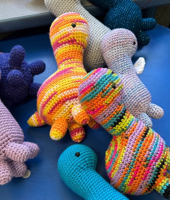 Crochet dinosaurs in a variety of colors and patterns.