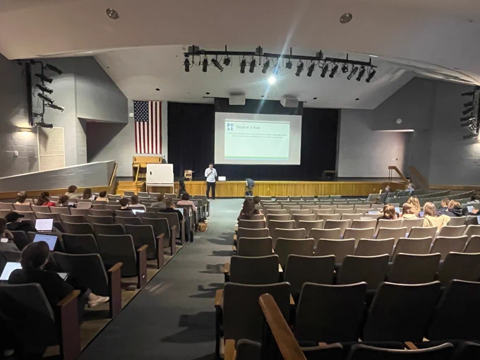 An auditorium full of teachers watching Day of AI trainer Jorge Gallardo explain AI tools for teachers