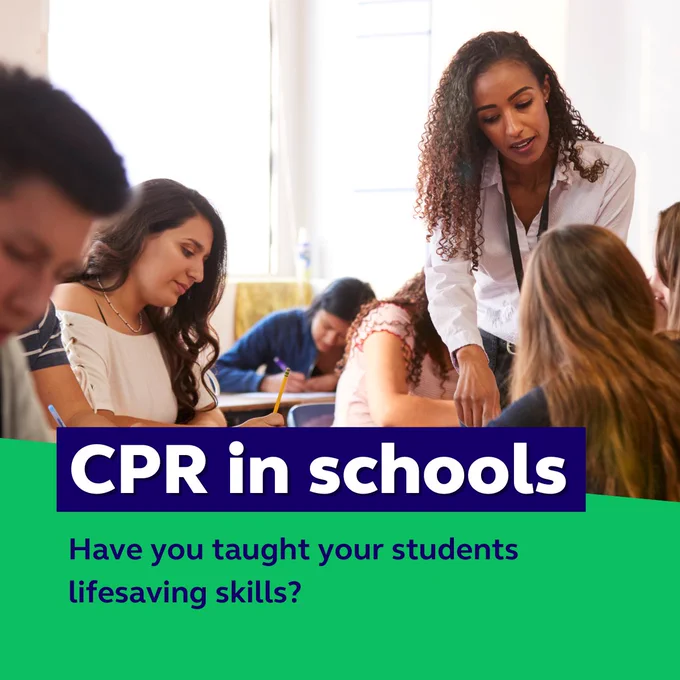 A teacher engages with a group of students in a classroom, assisting them with their work. The text overlay reads 'CPR in schools' in bold, with a subtitle asking, 'Have you taught your students lifesaving skills?’