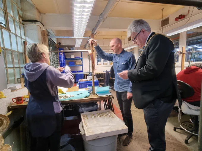 The Lord Mayor of Birmingham watches craftsmanship workers in action at ACME Whistles.