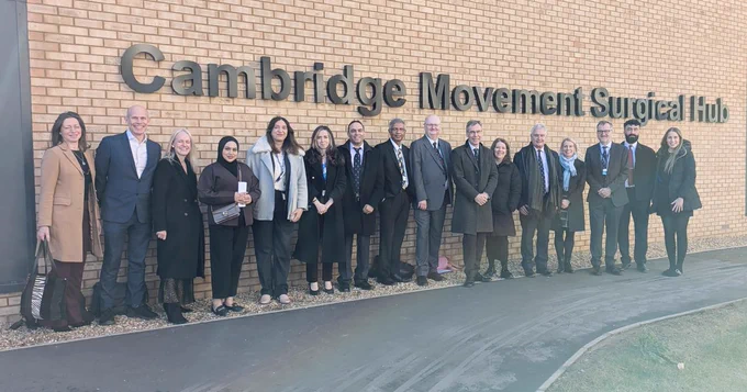 A group of people stand under a sign reading 'Cambridge Movement Surgical Hub'