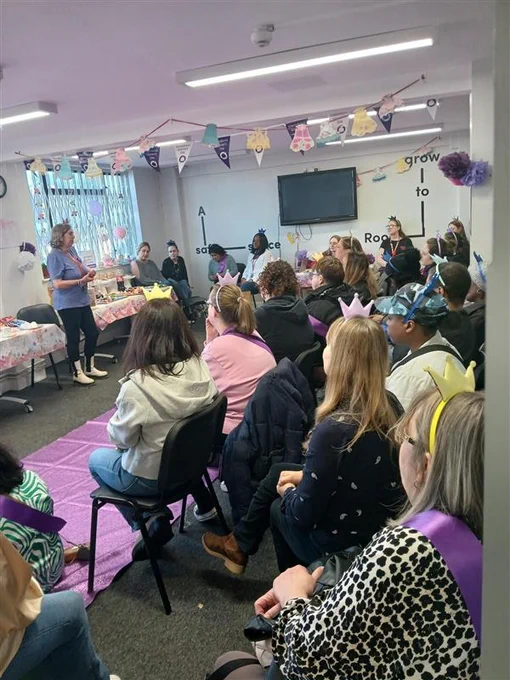decorated room with bunting celebrating international women's day with women wearing pastel coloured crowns