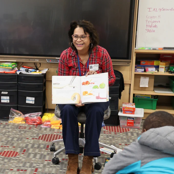 Woman reading to a classroom