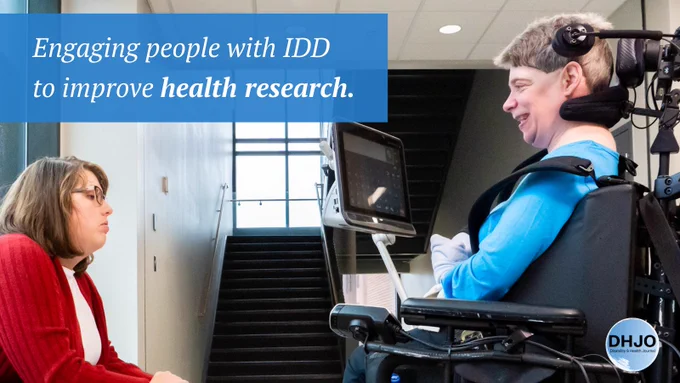 Engaging people with IDD to improve health research. Disability and Health Journal. Two women with disabilities meeting by a staircase. One is using a power wheelchair.