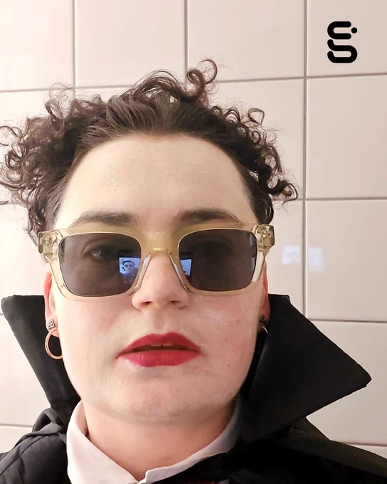 Performance artist Ali Wilson dressed as Dracula, wearing sunglasses.