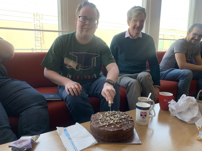 David cutting the celebratory cake at group coffee